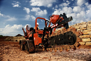 A Ditch Witch West ride-on trencher works towards irrigation system installation prep