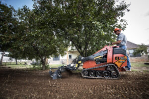 Mini skid steer operating in muddy jobsite conditions during spring to maintain productivity and traction