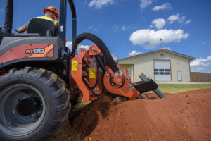 Ditch Witch RT80 ride-on trencher operating with a chain trencher attachment during underground utility installation