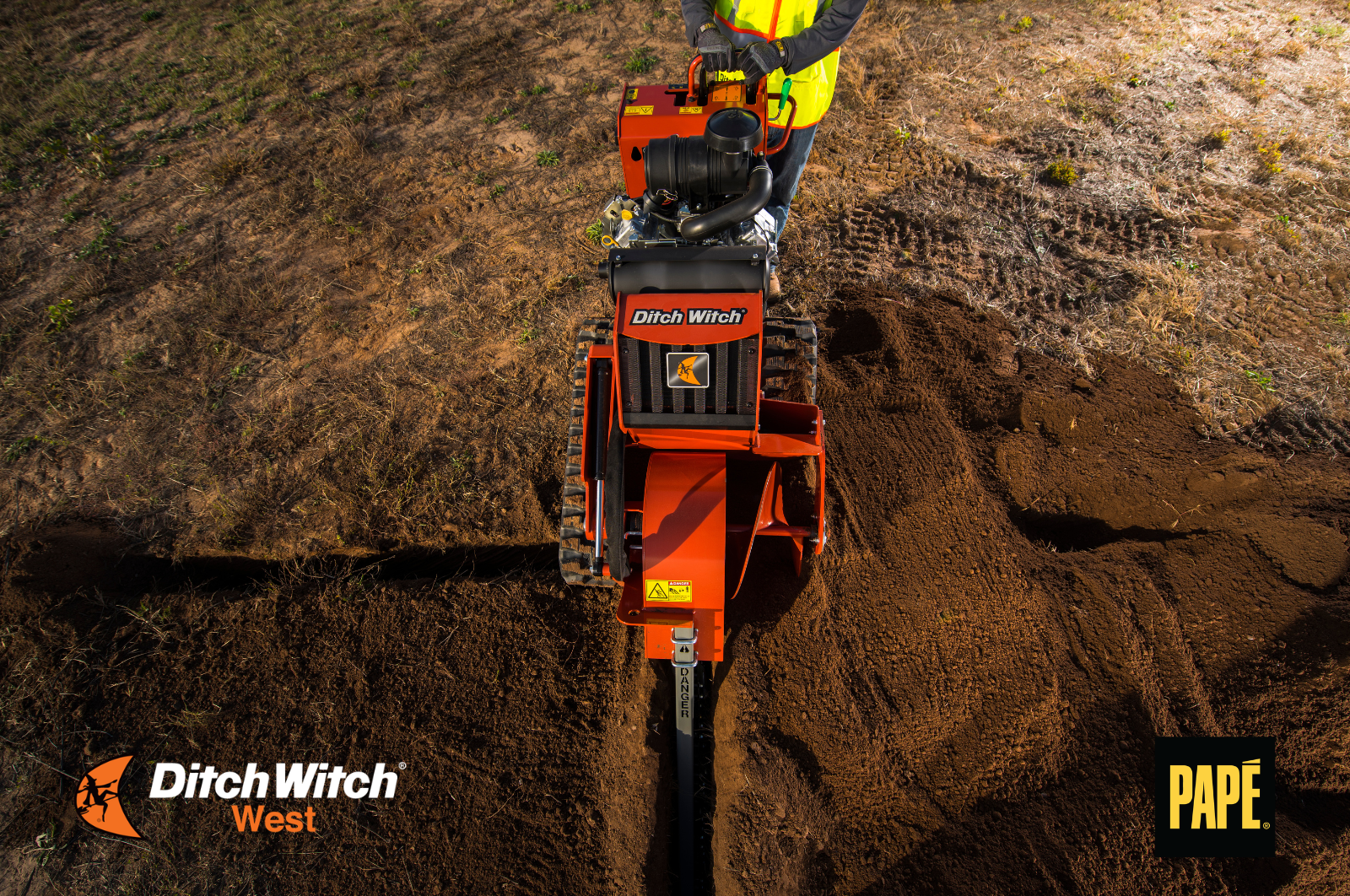 Walk-behind trencher digging a narrow trench for underground utility installation on a residential jobsite