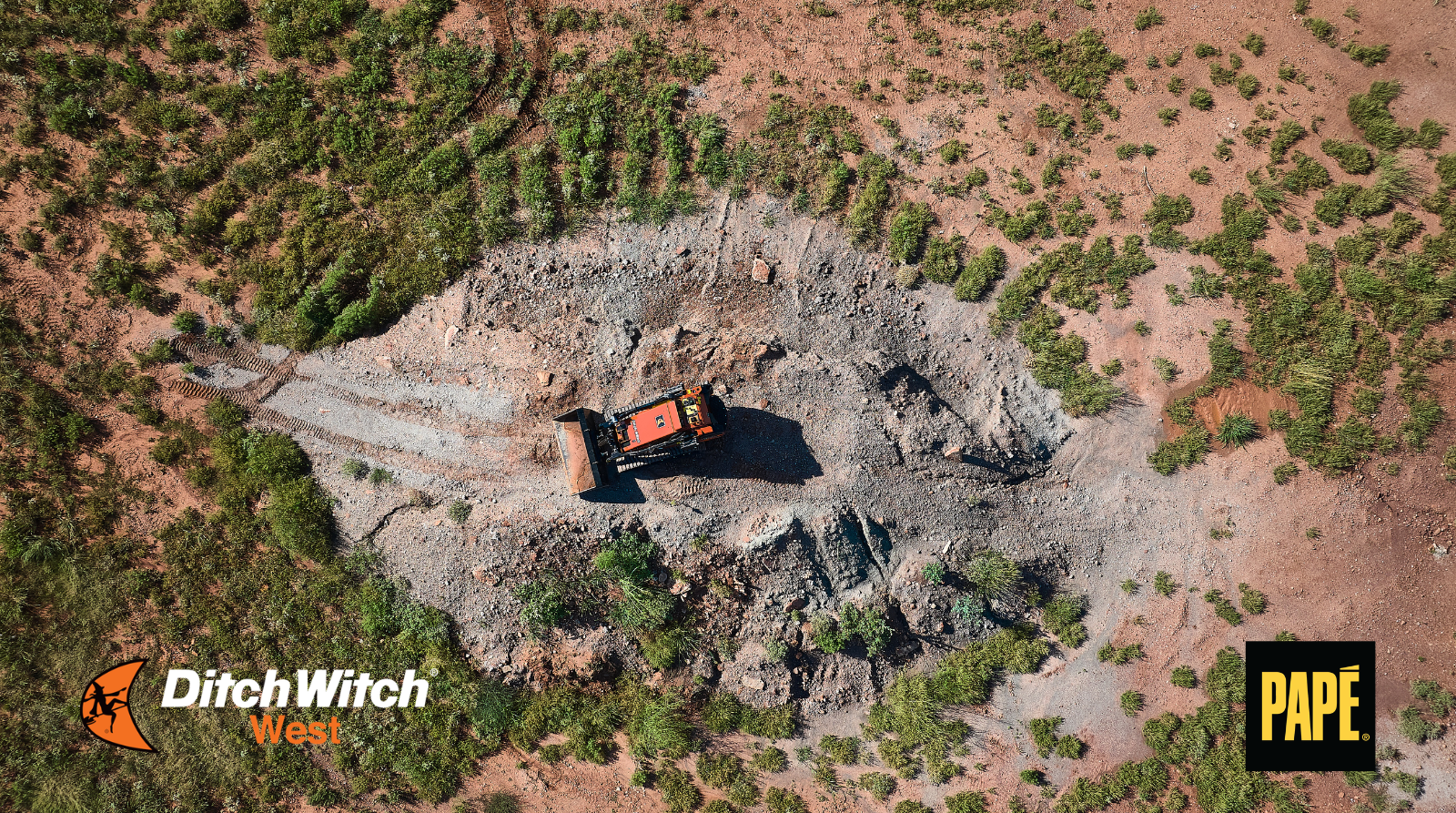 Aerial view of a Ditch Witch skid steer loader working on a construction site, showcasing compact equipment for earthmoving and grading.