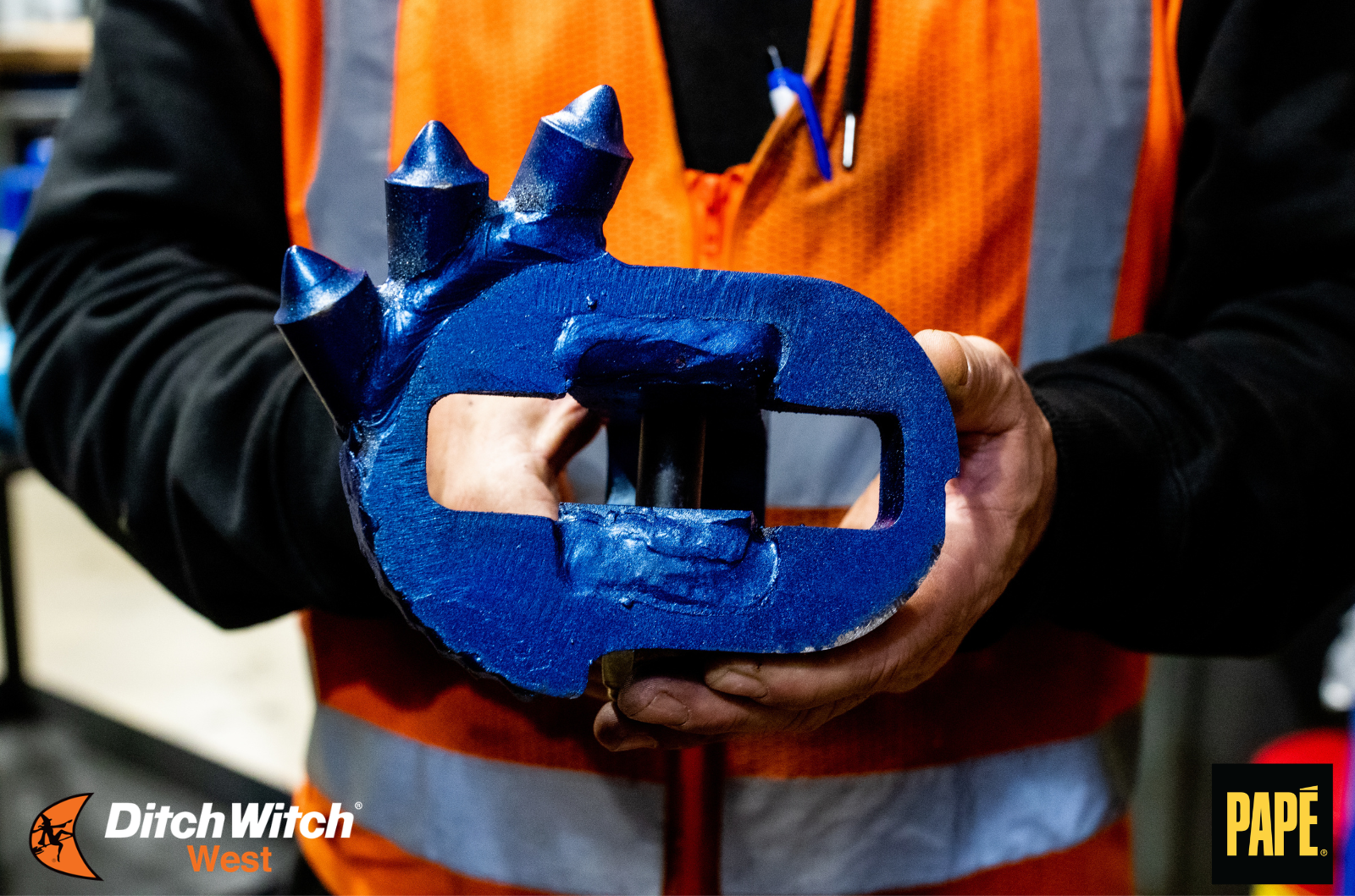 Worker holding a Radius HDD over-blade reamer used for horizontal directional drilling.