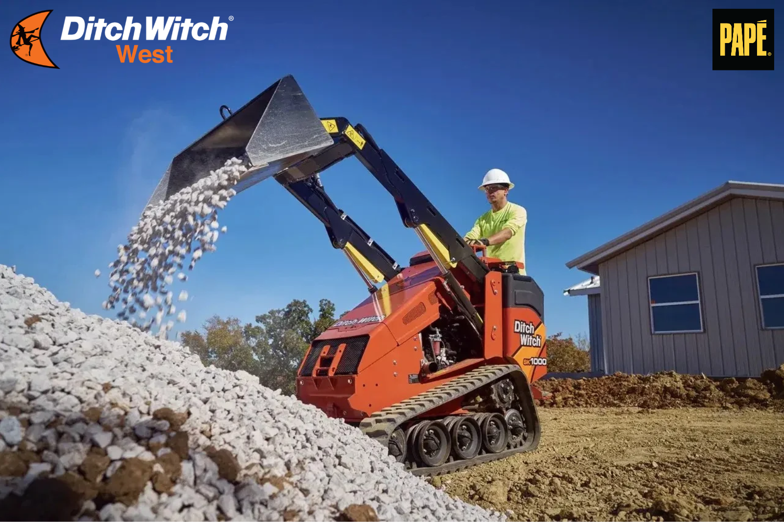 Ditch Witch SK1000 mini skid steer unloading gravel from its raised bucket onto a rock pile at a construction site.